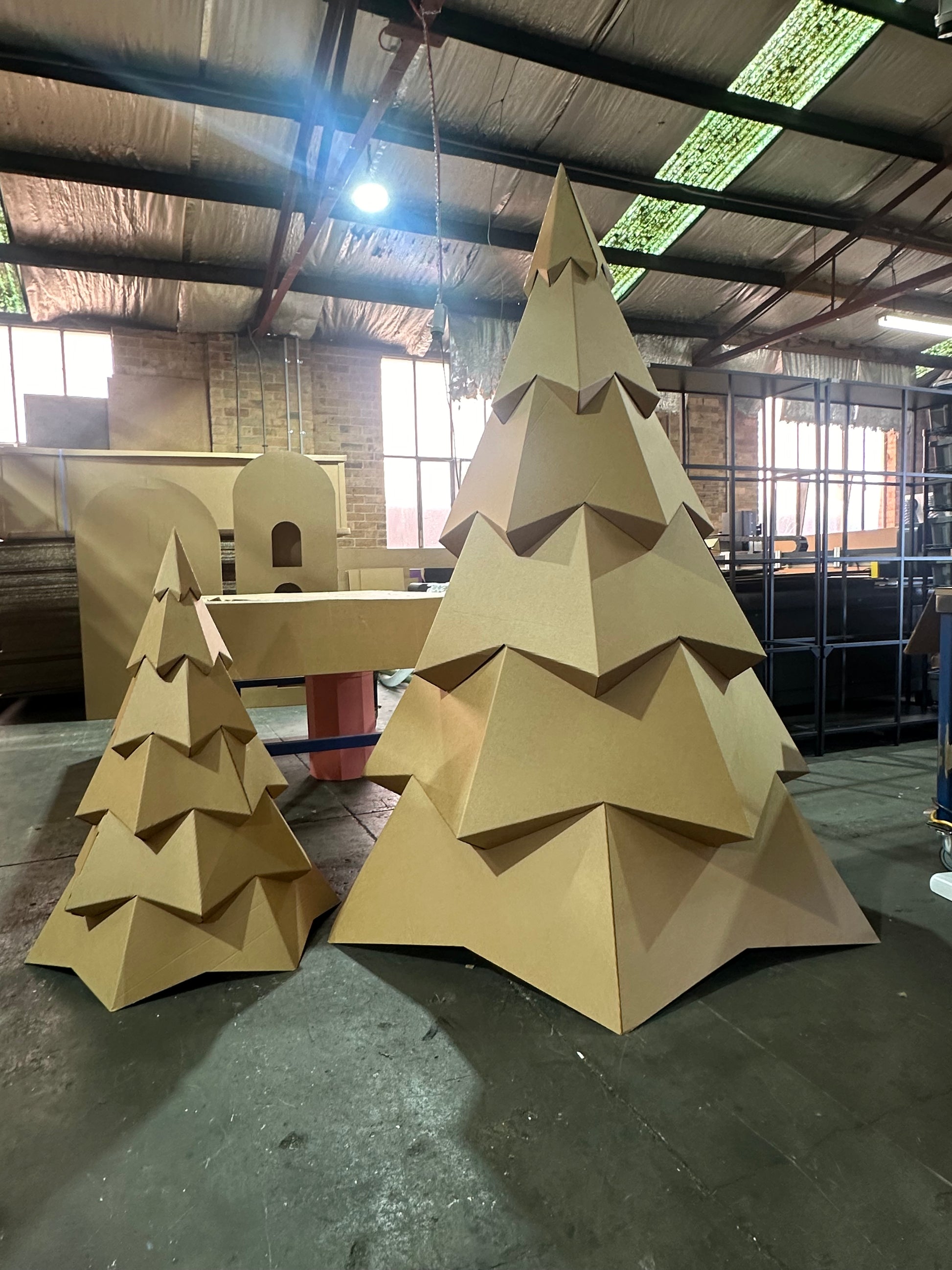 two cardboard trees setup next to each other. one large one and one small 