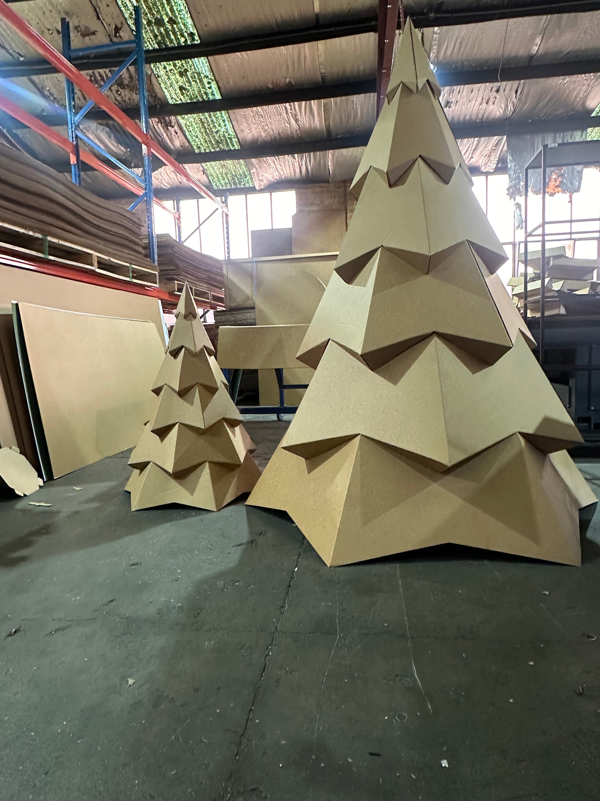 two cardboard trees setup next to each other. one large one and one small 